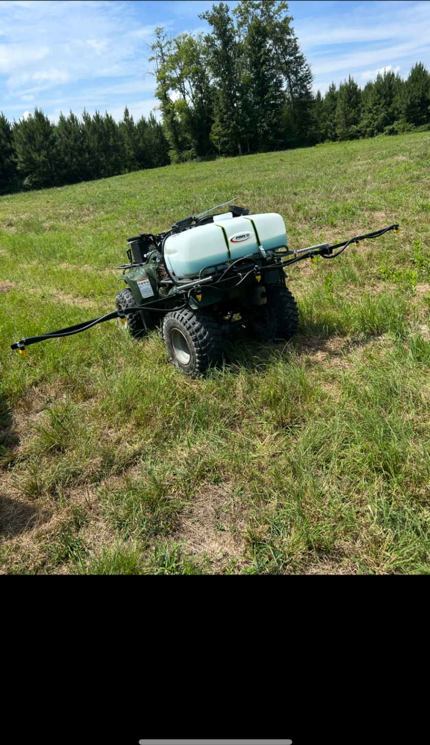 ATV sprayer setup in an open field for food plot maintenance work
