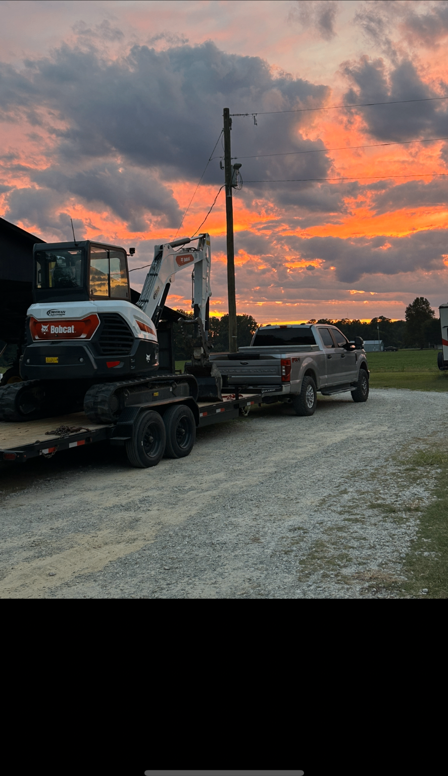 Bobcat excavator loaded on a trailer at sunset, ready for the next outdoor job